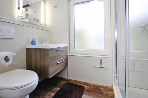 een badkamer met een toilet, een wastafel en een raam bij Cottage, Parchim in Parchim
