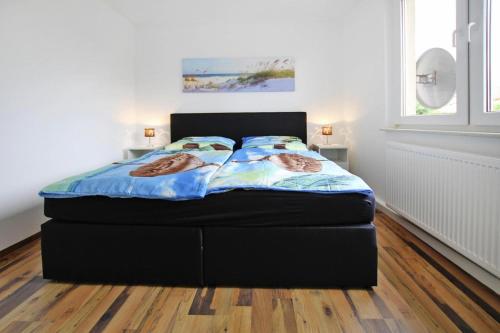 een bed in een slaapkamer met een zwart bedframe bij Cottage, Plau am See in Plau am See