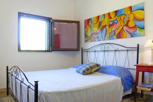 - une chambre avec un lit et une peinture murale dans l'établissement Holiday home, Carovigno, à Carovigno