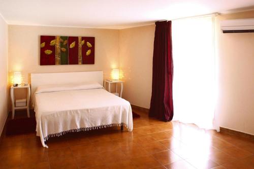 a bedroom with a bed and a painting on the wall at Holiday home, Castiglione di Sicilia in Castiglione di Sicilia