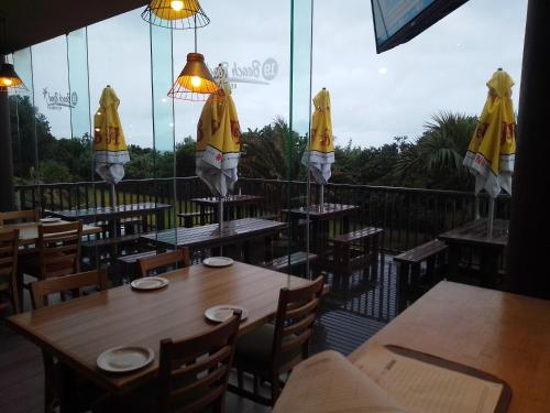 a restaurant with tables and umbrellas on a balcony at Afsaal Beach Heaven in Amanzimtoti
