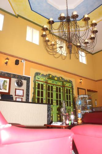 a dining room with a green cabinet and a chandelier at HotelSueño Dorado Aguadas in Aguadas