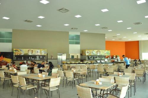 a dining room with tables and chairs and people eating at Prive Riviera Park - Caldas Novas in Caldas Novas