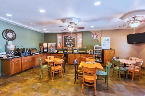 a dining room with tables and chairs and a restaurant at AmericInn by Wyndham Des Moines Airport in Des Moines