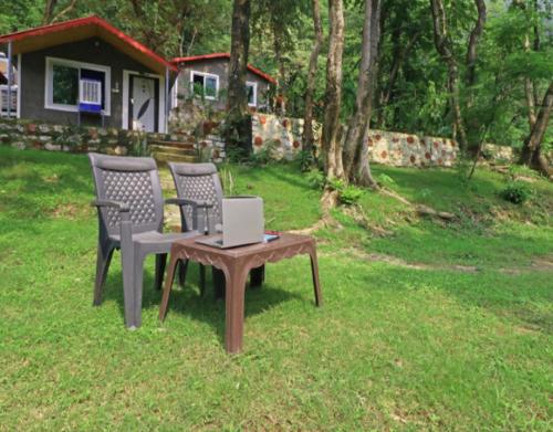 two chairs and a table with a laptop on it at Bird Retreat by StayApart, Rishikesh in Rishīkesh