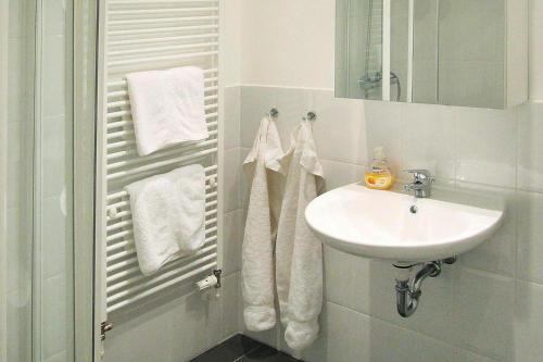 a white bathroom with a sink and a mirror at Mansion in Garz with garden in Garz-Rügen