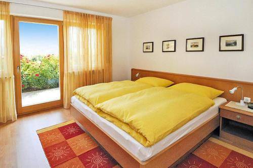 - une chambre avec un grand lit et une couverture jaune dans l'établissement Apartment in Schlanders with terrace, à Silandro