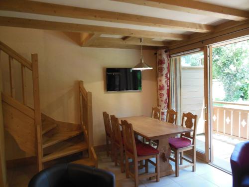 uma sala de jantar com uma mesa de madeira e cadeiras em Alpine Lodge 7 em Les Contamines-Montjoie