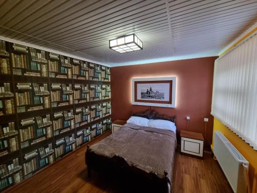 ein Schlafzimmer mit einem Bett und einer Bücherwand in der Unterkunft Hrachy Mot - Gyumri in Gjumri