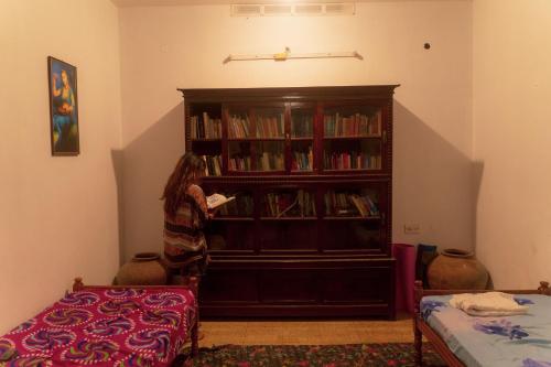a woman standing in front of a book shelf at Hope Hostels, Varkala - Helipad in Varkala