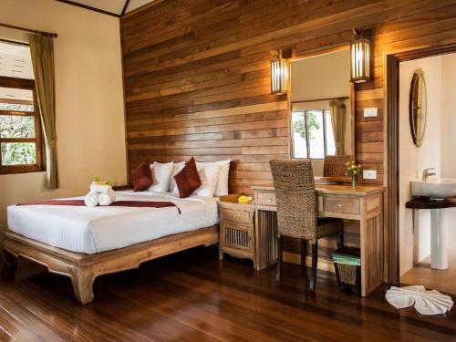 a bedroom with a bed and a desk in a room at Chaipura Resort in Ko Chang