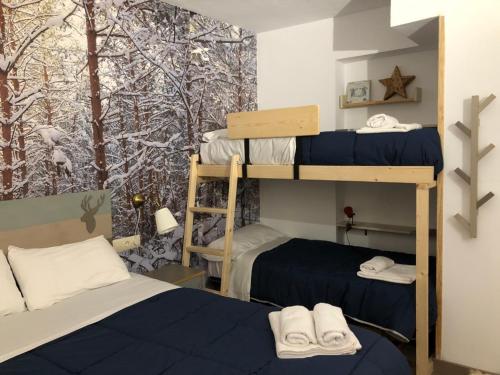 a bedroom with two bunk beds and a mural of trees at Apartament el Cérvol in La Molina