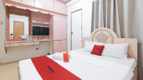 a pink and white bedroom with a bed and a mirror at Reddoorz @ Royal Grande Beach Resort Batangas in Batangas City