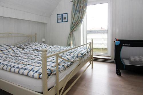 ein Schlafzimmer mit einem Bett und einem großen Fenster in der Unterkunft A holiday home in Büsum with a barbecue in Büsum