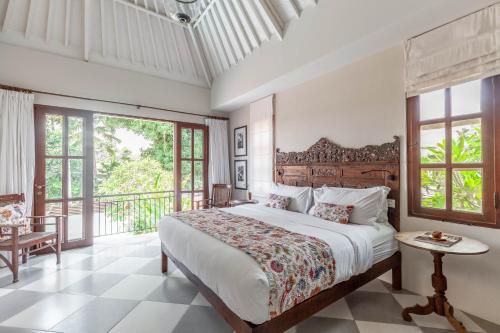 a bedroom with a large bed and a balcony at Villa Seni in Seminyak