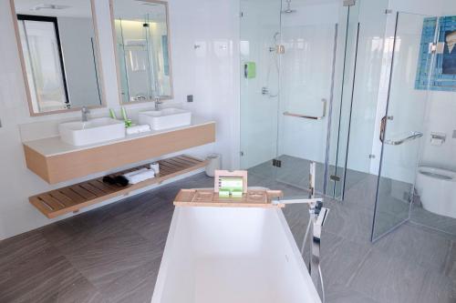 a bathroom with two sinks and a shower at Lime Resort Manila in Manila