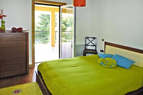 um quarto com uma cama verde com um urso de peluche em holiday home, Vale de Cambra - Rôge em Vale de Cambra