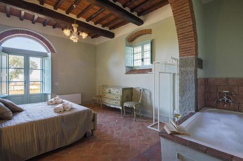 een slaapkamer met een bed en een bad bij Holiday home Villa Mezzavia, Castiglion Fiorentino in Cortona