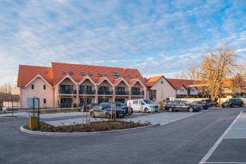 a large building with cars parked in a parking lot at Kistücsök Food & Room in Balatonszemes