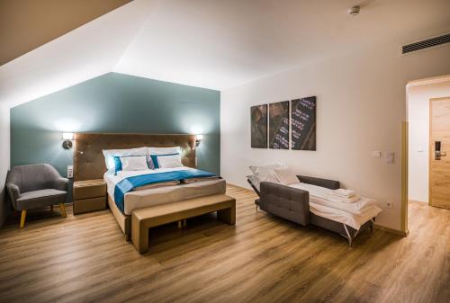 a bedroom with a bed and a chair in it at Kistücsök Food & Room in Balatonszemes