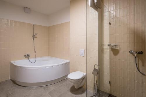 a bathroom with a tub and a toilet and a shower at Kistücsök Food & Room in Balatonszemes