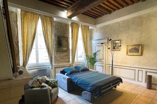 a bedroom with a bed and a couch and windows at Coeur Vieux Lyon, 60 M2 lumineux tout confort in Lyon