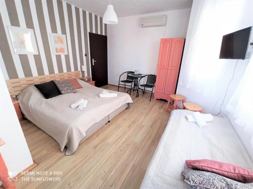 1 dormitorio con 2 camas y mesa con silla en Guest House Sunflowers, en Pomorie