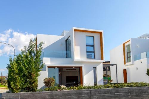 a white house with a fence in front of it at Villa Beach Heaven(Laurus 1), walking distance to the beach in Paphos