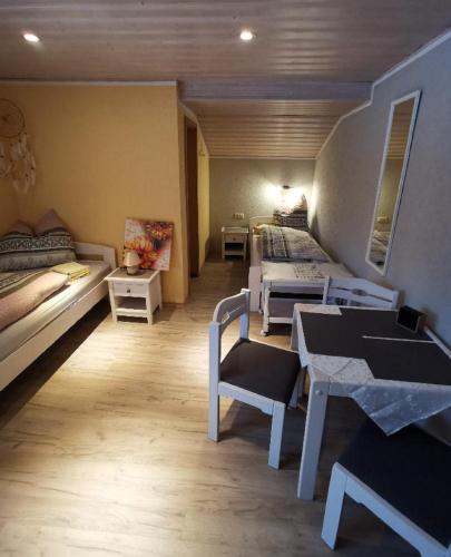 a room with two beds and a table in it at Pension Hüttendorf 49 gradnord in Bayerisch Eisenstein
