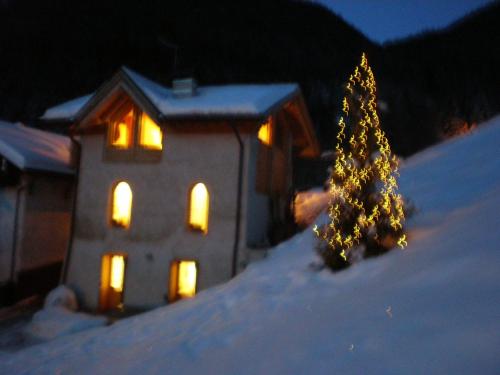 a christmas tree on top of a snow covered house at Ronchet Baita Vanoi Trentino in Ronco
