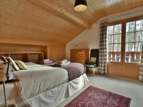 um quarto com uma cama grande e uma janela grande em Chalet Esprit em Morillon