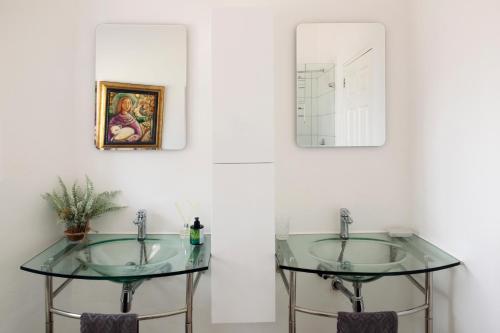 a bathroom with two glass sinks and a mirror at Sunshowers Plett in Plettenberg Bay