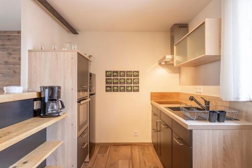 a large kitchen with wooden counters and cabinets at Le Meublé MONESTOIS in Mennetou-sur-Cher