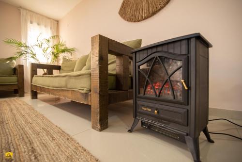 a fireplace in a living room next to a couch at צימר עלמא in Yeroẖam