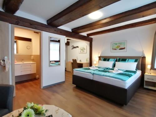 a bedroom with a large bed and a bathroom at Hotel garni "Alter Fritz" in Quedlinburg