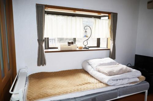 Bett in einem Zimmer mit Fenster in der Unterkunft Crane / Vacation STAY 564 in Kunisaki