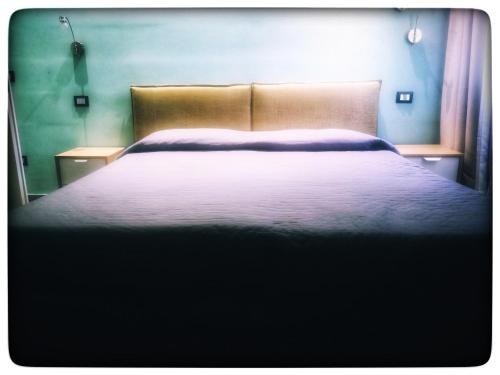 a bedroom with a large bed with a white blanket at Hotel La Cavalera in Augusta