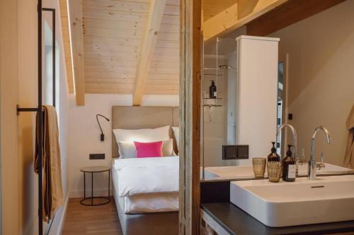 a bathroom with a sink and a bed in a room at DAS SALZBERG Hideaway Bad Aussee - Adults only in Bad Aussee