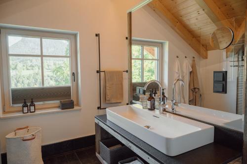 a bathroom with a sink and a large mirror at DAS SALZBERG Hideaway Bad Aussee - Adults only in Bad Aussee