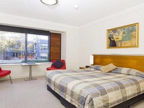 um quarto com uma cama, uma secretária e uma janela em Harbourside Views 503 Sebel Kiama em Kiama