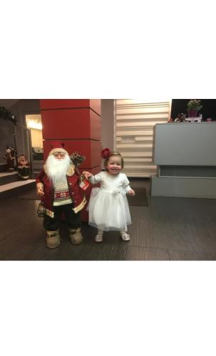 a little girl standing next to a santa claus at Hotel Vandia in Timişoara