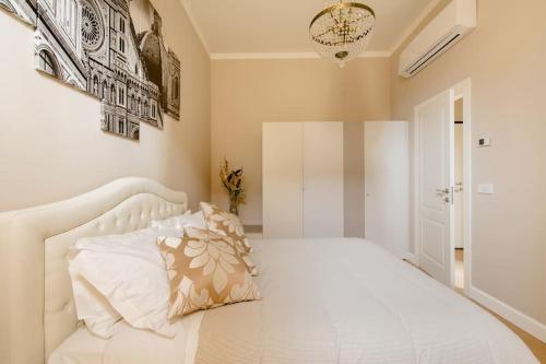 ein Schlafzimmer mit einem weißen Bett und einem Kissen darauf in der Unterkunft Duomo Luxury Home with view in Florenz