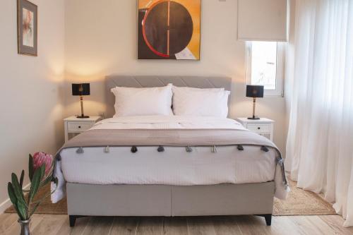 ein Schlafzimmer mit einem großen Bett mit zwei Nachttischen in der Unterkunft Chrysalis 2 in Kos-Stadt