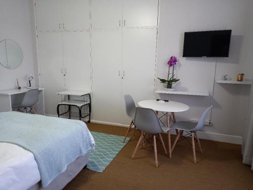 a bedroom with a bed and a table and chairs at Innes Road Durban Accommodation Private Double Room with Private Bathroom in Durban