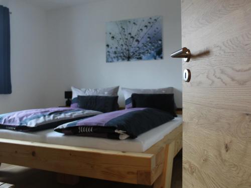 バート・エンドルフにあるFerienwohnung an der Jodquelleのベッドルーム(紫色の枕を使用したベッド2台付)