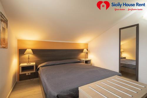 a bedroom with a bed and a large mirror at Borgo Aranci - Appartamento in Villa Garofalo - 15B in Castellammare del Golfo