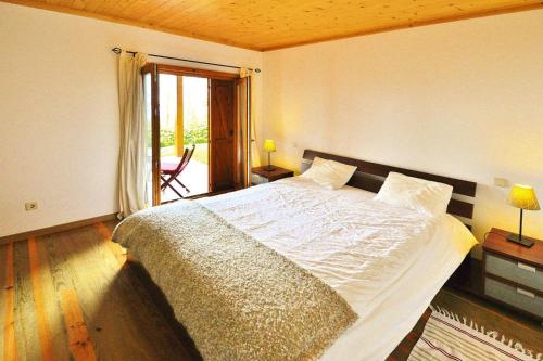 ein Schlafzimmer mit einem großen Bett in einem Zimmer in der Unterkunft Holiday homes Quinta dos Curubás, Vila Franca do Campo in Vila Franca do Campo