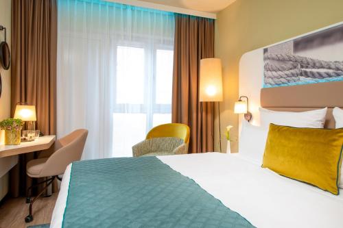 A bed or beds in a room at Leonardo Hotel Hamburg Altona