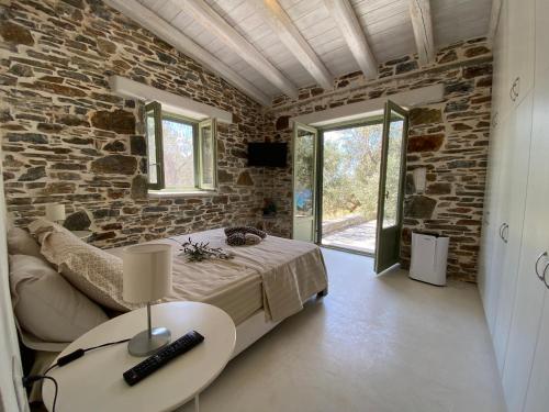 a bedroom with a bed and a stone wall at Sun Senses - villa with private beach in Ayía Marína
