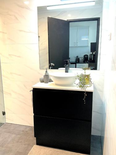 a bathroom with a sink and a mirror at Heart of Manly Apartment in Sydney